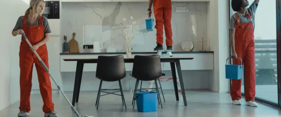 eol Team of professional cleaners in red uniforms mopping floors and cleaning windows in a modern office space – expert office cleaning services and commercial office cleaning.
