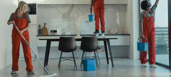 eol Team of professional cleaners in red uniforms mopping floors and cleaning windows in a modern office space – expert office cleaning services and commercial office cleaning.
