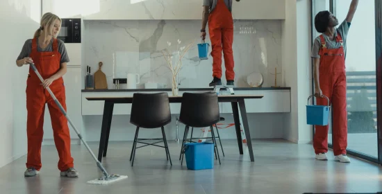 eol Team of professional cleaners in red uniforms mopping floors and cleaning windows in a modern office space – expert office cleaning services and commercial office cleaning.